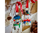 Two toy snowman ornaments hanging from a branch with red ribbons.