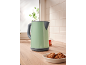 Green electric kettle on a wooden kitchen counter with cookies and tea.