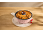 Cake in a pink bundt pan on a marble board, garnished with raspberries.