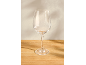 Empty wine glass on a wooden table against a light wall