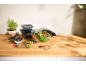 Glass bowls with lids, filled with salad, yogurt, and olives, on a wooden countertop.