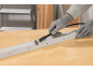 Work gloves cutting a metal profile with a rotary tool.