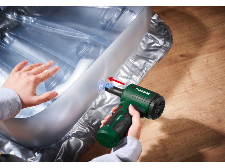 Green electric inflator inflating a transparent inflatable mattress on a wooden floor.
