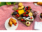 Picnic spread with cheese, berries, crackers, chocolate, jam, and croissants.