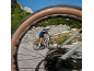 Cyclist on a mountain bike on an asphalt road, shot through a wheel.