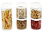 Transparent storage containers with pasta, oats, granola, hazelnuts, and dried strawberries.