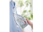 Handheld steam iron steaming a blue shirt hanging on a hanger.
