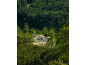 Two cyclists on a winding mountain road, surrounded by dense forest.