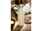 Insulated bottle on a wooden table with a coffee cup, keys, and a striped bag.