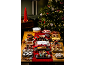 Christmas table laden with sweet treats, including trifle, cheesecake, cakes, and macarons, with a Christmas tree.