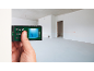 Laser distance measurer measuring distance in an empty room.