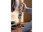 Handheld pepper grinder over steak with vegetables.