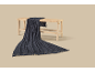 Dark blue knitted throw draped over a light wooden bench with a woven seat.
