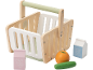 Wooden toy shopping basket with milk, juice, orange, and cucumber.