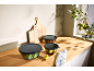 Kitchen counter with three food storage containers, cutting boards, and a lemon.