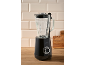 Black blender with a glass jug on a wooden countertop against light tiles.