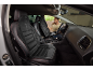 Man installing black car seat covers with red accents.