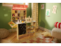Wooden toy market stall with basket and food accessories in a child's room with Christmas drawings.