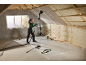 Woman sanding drywall on the ceiling with a sander in an attic.