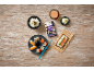 Overhead view of a sushi rice package, a sushi set, a bowl of rice, and ginger on a wooden table.