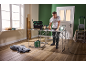 Man in a workshop with a work table, tools, and a work light, planning a project.