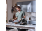 Man in kitchen, closing a lidded glass container next to a food processor.