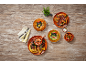 Spanish tortillas with chorizo and peppers, served with garnishes on a wooden table.