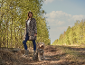 Woman and dog in leopard print coats on a forest path