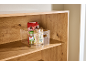 Clear organizer with grains and spices on a wooden shelf.