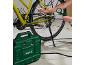 A green air compressor inflates a bicycle tire, with a pressure gauge displaying the pressure.
