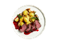 Roast beef with potatoes, mushrooms, and berry sauce on a white plate.