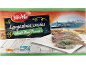 Box of frozen whole raw prawns with a Mediterranean port in the background.