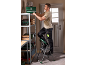 Man on a stepladder placing a green toolbox onto a metal shelf.