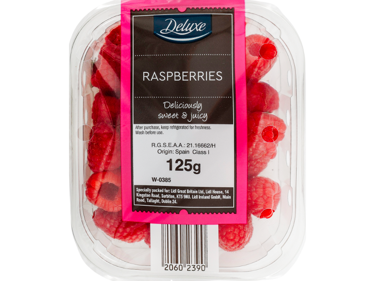 Fresh raspberries in a clear container with a pink and black label.