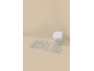 Two beige striped bath mats and a wall-mounted toilet in a beige bathroom.
