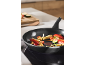 Frying pan with chopped vegetables on an induction hob.