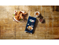 Chocolate croissants on a wooden board with berries, coffee, and a pack of croissants.