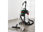 Wet and dry vacuum cleaner with a metal tank and wet cleaning nozzle on a floor with water.