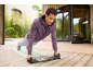 Man doing push-ups on a push-up board outdoors, wearing a purple hoodie.