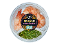 Latin American style prawns with a green chimichurri dip in a transparent container.