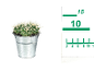 Cactus in a metal pot with a measuring ruler next to it.