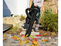 Cordless electric leaf blower used to clear autumn leaves from a paved pathway.