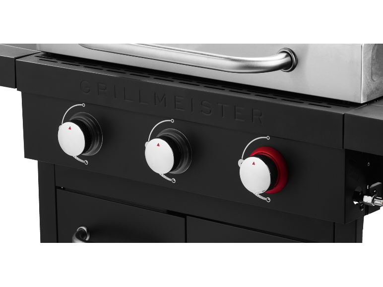 Gas barbecue control panel with three knobs and the inscription «GRILLMEISTER».