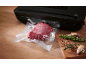 Black vacuum sealer with a piece of packaged meat and fresh herbs