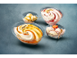 Four bowls of ice cream, including vanilla and fruit, some with Deluxe decorations.