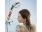 Woman in shower with a filtering shower head containing mineral balls.