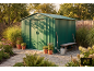 Green garden shed with tools and plants in a sunny garden.