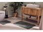 Grey bath mats in a modern bathroom with a wooden vanity unit and plants.