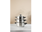 Stack of three stainless steel pots with lids on a white marble surface.