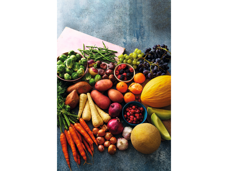 Assortment of fresh fruits and vegetables, including carrots, potatoes, green beans, and melons.